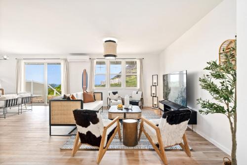 a living room with a couch and a table and chairs at @ Marbella Lane - Mesmerizing Ocean + MT Views in Waianae