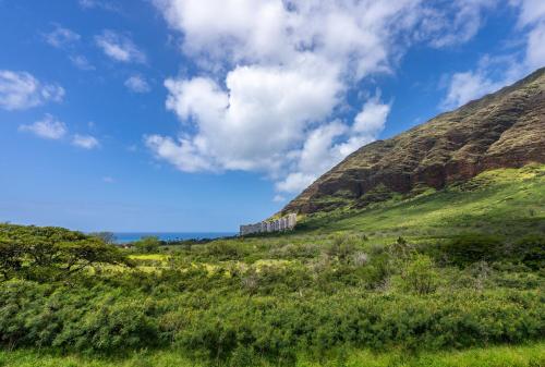 a green hill with a blue sky and clouds at @ Marbella Lane - Mesmerizing Ocean + MT Views in Waianae