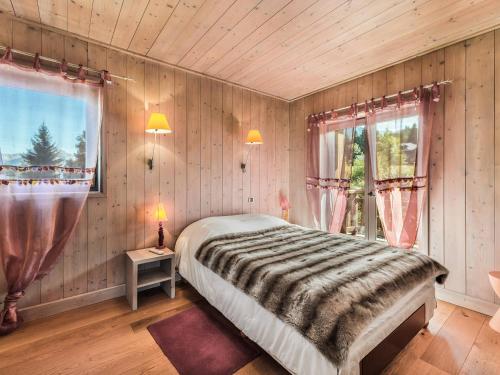 une chambre avec un lit dans une pièce aux murs en bois dans l'établissement Appartement 5 pièces luxe au centre de Megève, proche télécabines, 4 chambres, garage, balcon - FR-1-453-168, à Megève