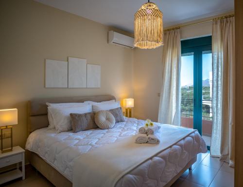 a bedroom with a large white bed with a chandelier at Helen Sweet Home in Kounoupidhianá