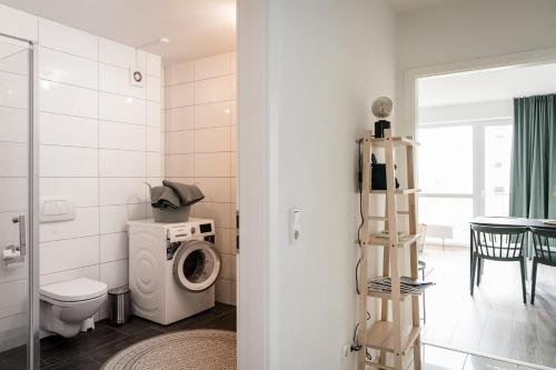 a bathroom with a toilet and a washing machine at Fischtown Apartment II in Bremerhaven