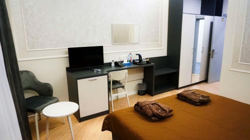 a room with a bed with a desk and a chair at Sun City Hotel & Spa Naftalan in Naftalan