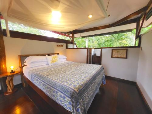 a bedroom with a bed in a house at Casa Cayuco Eco-Adventure Lodge in Bocas del Toro