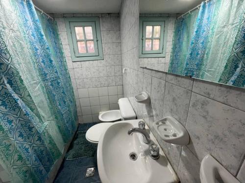 baño con lavabo y espejo y 2 aseos en El Farolito House Bariloche en San Carlos de Bariloche