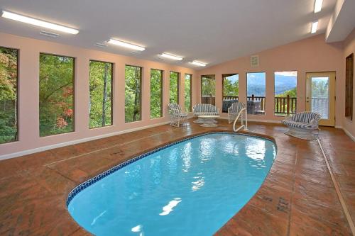 uma grande piscina num quarto com janelas em Splash Mansion #500 em Gatlinburg
