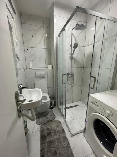 y baño con ducha, aseo y lavamanos. en One bedroom apartment in great location, en Podgorica
