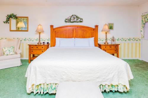 a bedroom with a large white bed and a chair at Azalea Garden Inn in Blowing Rock