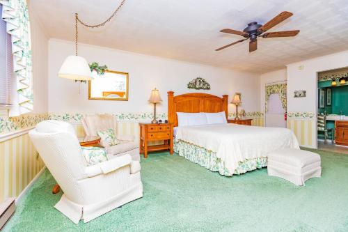 a bedroom with a bed and a chair at Azalea Garden Inn in Blowing Rock
