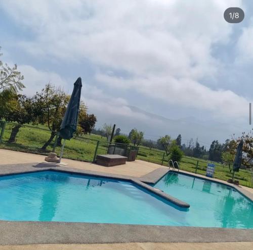 a large swimming pool with an umbrella in a yard at Pueblo Andaluz Olmué in Olmué
