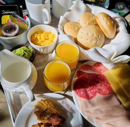 una mesa cubierta con platos de desayuno y zumo de naranja en Pueblo Andaluz Olmué en Olmué