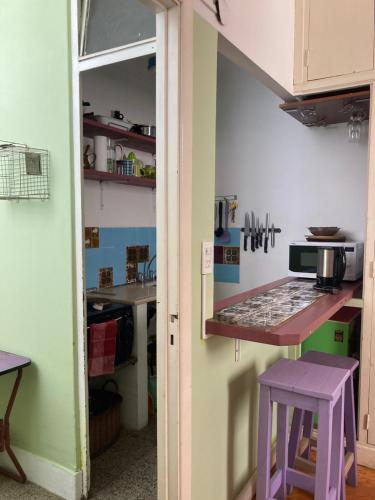 eine Küche mit einer Theke und einem lila Stuhl in der Unterkunft Apartment Corazón de San Telmo in Buenos Aires
