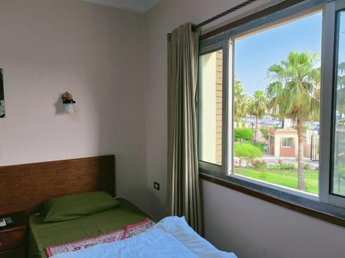 a bedroom with a bed and a large window at بيت الشباب الاسماعيلية - Ismailia Youth Hostel in Ismailia