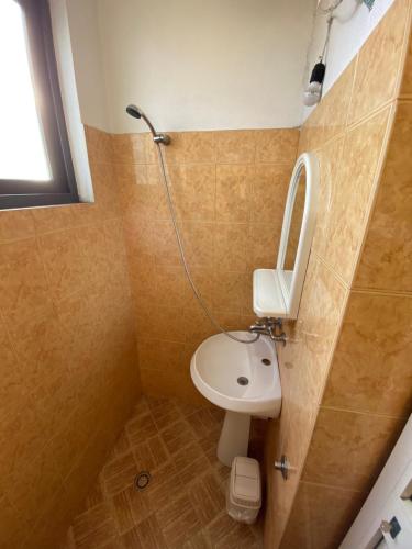 a small bathroom with a sink and a mirror at Villa Osmani in Durrës