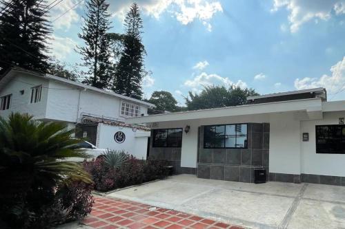 a white house with a driveway in front of it at Hotel 12 Nights in Medellín