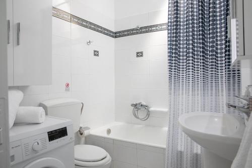a white bathroom with a toilet and a sink at Iliana's House in Zipárion