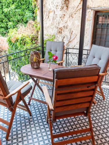 a patio with a wooden table and two chairs at Bella Vasilica Luxury Apartments in Parga