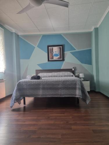 1 dormitorio con 1 cama con pared azul en Habitación Villena lavanda, en Villena