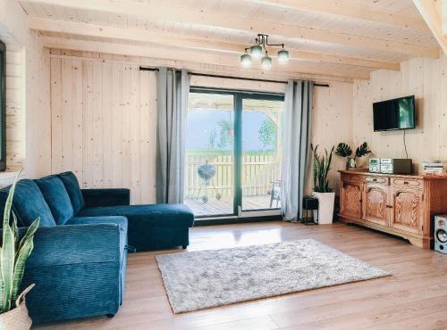 un soggiorno con divano e una grande finestra di JEZIORAKI Wyjątkowe domki 500m od jeziora Nowa Jedlanka a Uścimów