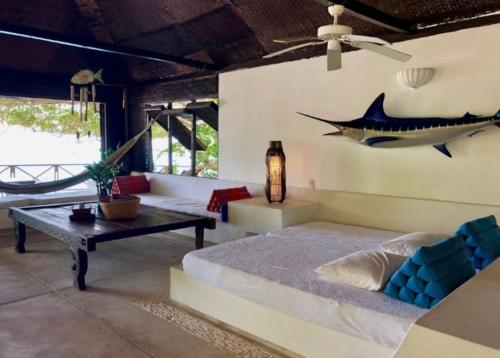 uma sala de estar com uma cama e um peixe na parede em Isla Única em Isla Grande