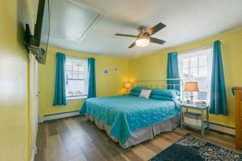 a bedroom with a bed and blue curtains at 34 Dillingham Avenue Sandwich Cape Cod - Aloha in Sandwich