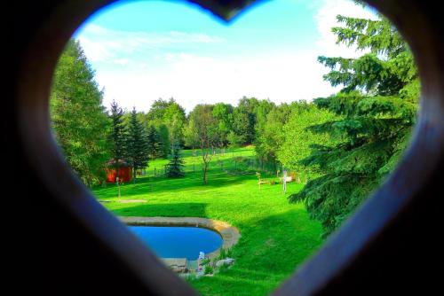 a heart shaped view of a park from a window at Guest House Sněžník in Sněžnik