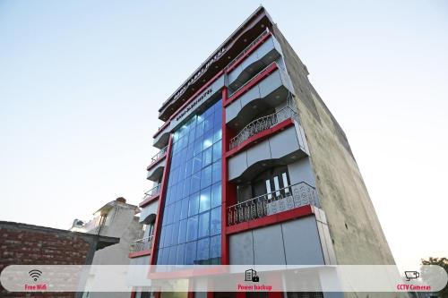 um edifício alto com uma fachada vermelha e azul em SPOT ON Hotel Doon Sabri em Roorkee