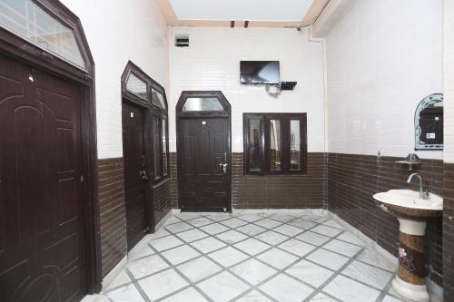 ein Badezimmer mit zwei braunen Türen und einem Waschbecken in der Unterkunft SPOT ON Hotel Doon Sabri in Roorkee