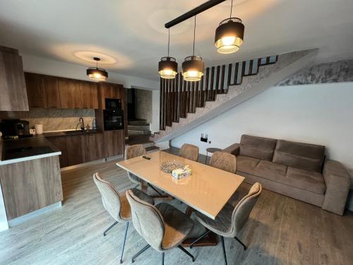 eine Küche und ein Wohnzimmer mit einem Tisch und einem Sofa in der Unterkunft Kul House - Cazare in Băileşti