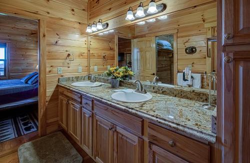 La salle de bains est pourvue de 2 lavabos et d'un grand miroir. dans l'établissement Majestic View Lodge #426, à Sevierville