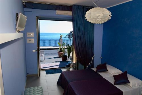 a bedroom with a bed and a view of the ocean at Casa Mare in Giardini Naxos