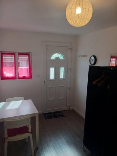 une chambre avec une porte, une table et une horloge dans l'établissement studio cool, à Bonsecours