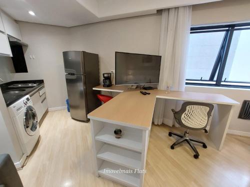 a kitchen with a desk and a refrigerator at Bienal Ibirapuera in Sao Paulo