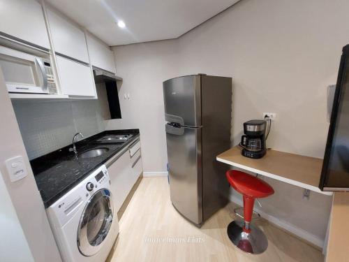 a kitchen with a stainless steel refrigerator and a washing machine at Bienal Ibirapuera in Sao Paulo