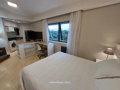 a bedroom with a bed and a desk and a window at Bienal Ibirapuera in Sao Paulo