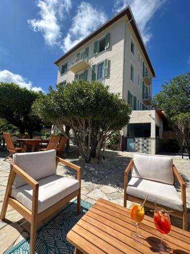 two chairs and a table in front of a building at Hôtel Miramar in Vence