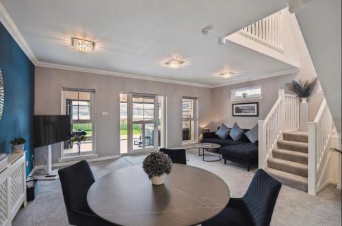 a living room with a table and a couch at Little Gleddoch in Dumbarton