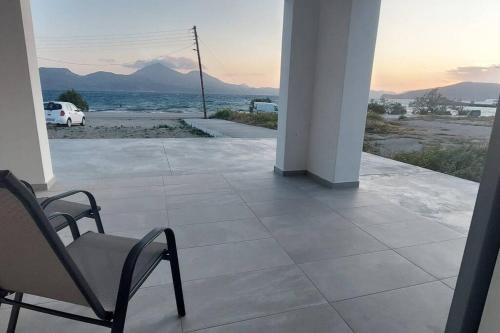 a chair on a porch with a view of the ocean at Bay-dream 3 in Adamantas