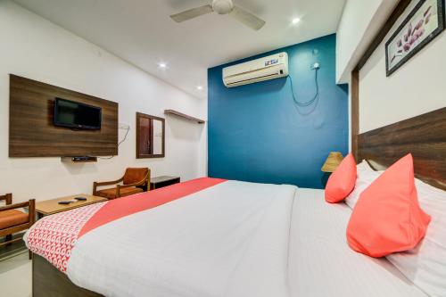 1 dormitorio con cama blanca y pared azul en OYO Hotel Meredian Orchid Near Birla Mandir en Hyderabad