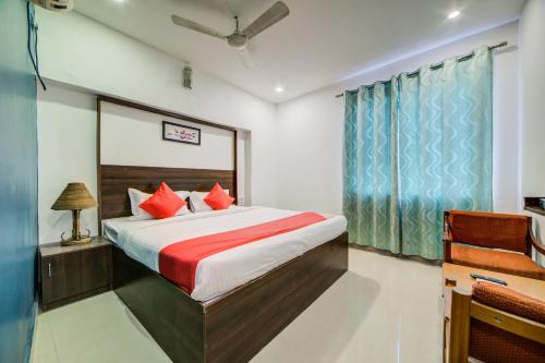 ein Schlafzimmer mit einem großen Bett mit roten Kissen in der Unterkunft OYO Hotel Meredian Orchid Near Birla Mandir in Hyderabad