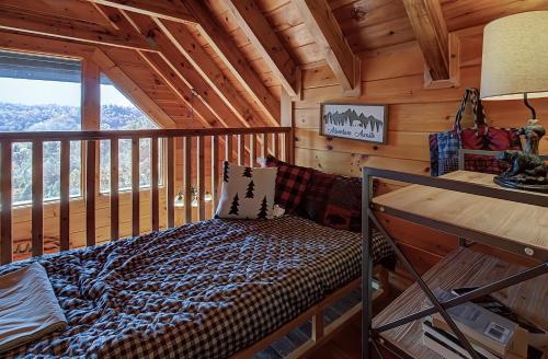 Dormitorio en cabaña de madera con cama en el balcón en Bearview Heights #244, en Townsend