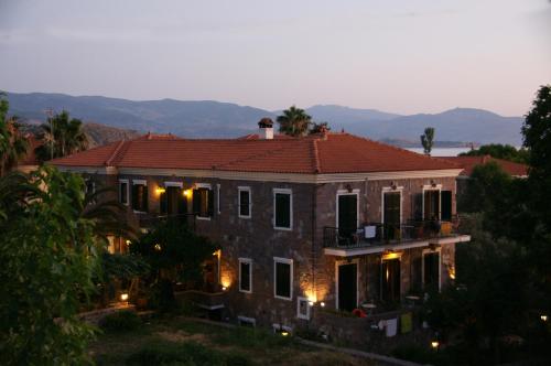 a large brick house with a red roof at Hotel Adonis in Mithymna