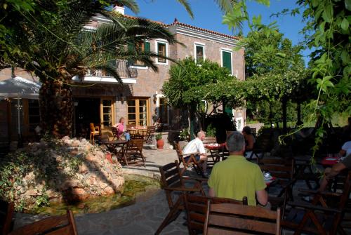a group of people sitting in chairs in front of a building at Hotel Adonis in Mithymna
