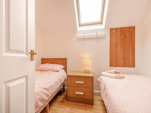 a small bedroom with two beds and a window at The Cottage - Uk43952 in Boosbeck