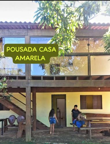 沙帕達－杜斯吉馬朗伊斯的住宿－POUSADA CASA AMARELA，站在建筑物外的男女