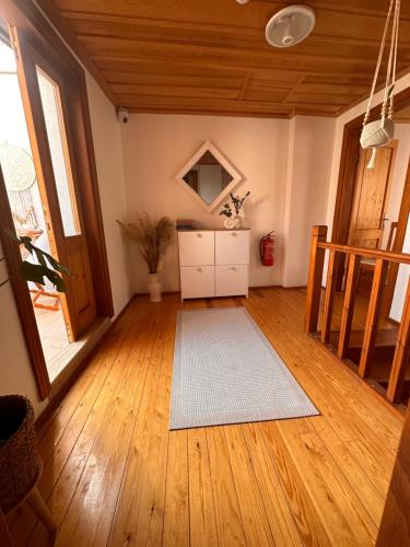 a living room with a white rug on a wooden floor at Hanole Guest House in Ayvalık