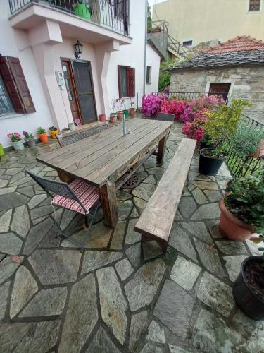 a wooden table and a bench on a stone patio at Orizontas Pilio Villa in Kissós