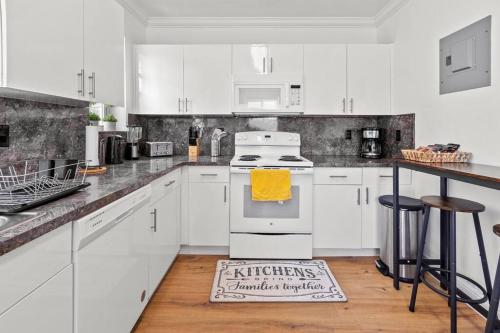 a kitchen with white appliances and a rug on the floor at Comfy & Updated Apartment centrally located minutes away from everything! in Miami