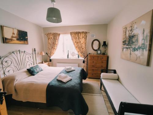 um quarto com uma cama, um banco e uma janela em Tower View Lodge em Ennis