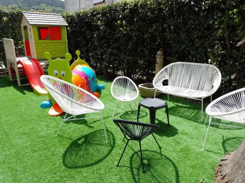 a group of chairs and a playground in a yard at ALBACHIARA INN Residence Apartments in Ameglia