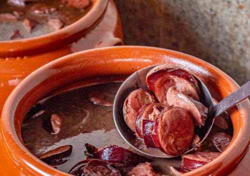 a bowl of meat with a spoon in it at Hotel Ponta Verde Maceió in Maceió